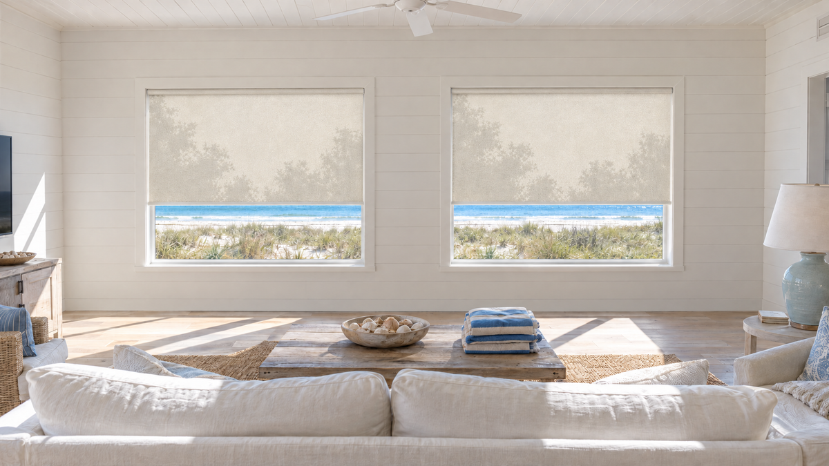 Solar Shades in Ivory — a bright beach house living room on the second floor of a raised coastal home, early afternoon