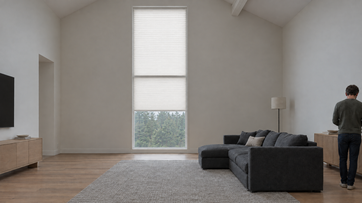 Light Filtering Cellular Shades in White — a residential great room with a very tall window under a vaulted ceiling, midday under heavy overcast