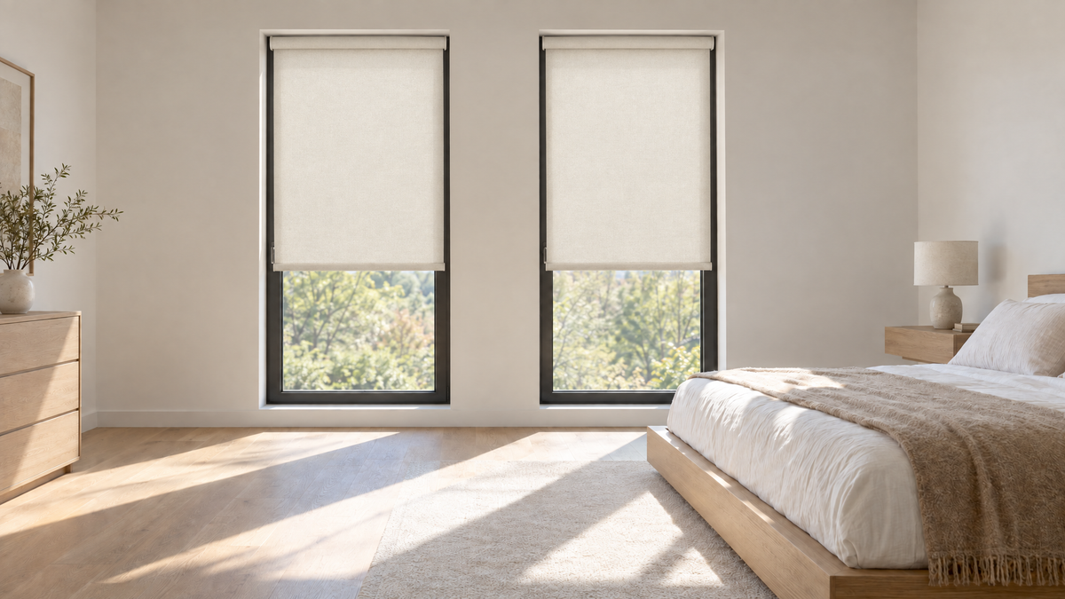 Light Filtering Roller Shades in Ivory — Ultra-realistic interior photograph, 3:1 ultra-wide aspect ratio, of a primary bedroom in a newly built modern home, late morning with bright directional sun